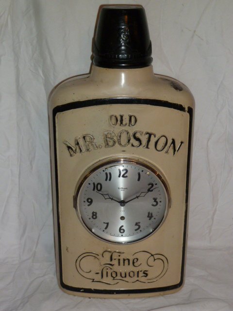 GILBERT OLD MR. BOSTON ADVERTISING CLOCK: SHOWING A GILBERT OLD MR BOSTON 8 DAY METAL ADVERTISING CLOCK , METAL CASE IS MODELED AFTER A FLASK BOTTLE . MEASURES 21 1/2" X 10 1/2" AND 5 1/2" DEEP. THE ABSENCE OF A CONDITION REPORT DOES NOT GUAR