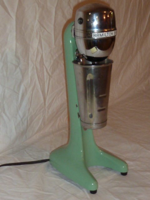 VINTAGE HAMILTON BEACH MILKSHAKE MIXER: SHOWING A VINTAGE HAMILTON BEACH MALTED MILK MIXER . GREEN ENAMEL , MINOR CHIP ON BASE , NORMAL WEAR . MEASURES . THE ABSENCE OF A CONDITION REPORT DOES NOT GUARANTEE EXCELLENT CONDITION.PLEASE CONTAC