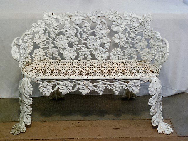 1870'S CAST IRON AMERICAN BENCH JOHN McLEAN MAKER: SHOWING A VICTORIAN CAST IRON AMERICAN BENCH IN THE GRAPEVINE PATTERN . BARREL - FORM BACK , RETICULATED SEAT , OUTSWEPT LEGS .SECOND OF TWO IN SALE . MEASURES 31" HIGH 44" WIDE AND 14" DEEP SEAT. THE