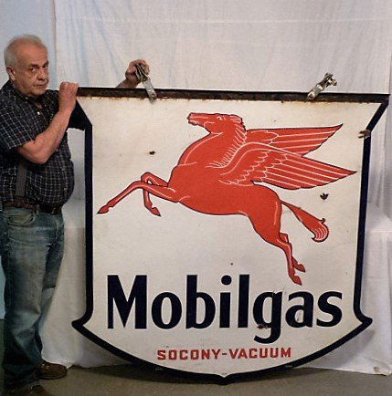 MOBILGAS DOUBLE SIDED PORCELAIN PEGASUS SIGN: SHOWING A OUTSTANDING LARGE MOBIL GAS DOUBLE SIDED PORCELAIN SHIELD SHAPED SERVICE STATION SIGN WITH PEGASUS LOGO . SOCONY-VACUUM , HAS ORIGINAL BRACKET HOOKED TO SIGN AND METAL HANGERS . MEASURES 56"