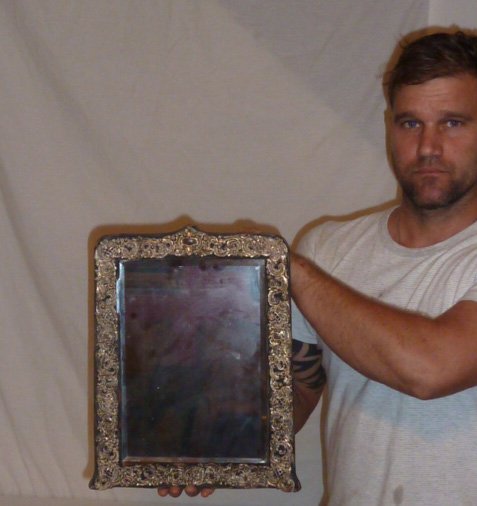 ANTIQUE MIRROR WITH STERLING REPOSSE BORDER: SHOWING A ANTIQUE MIRROR WITH STERLING REPOSSE BORDER. MEASURES 15" BY 11". AS FOUND ESTATE CONDITION.PLEASE USE PHOTOS AS PART OF THE DESCRIPTION. THE ABSENCE OF A CONDITION REPORT DOES NOT GUARANTEE