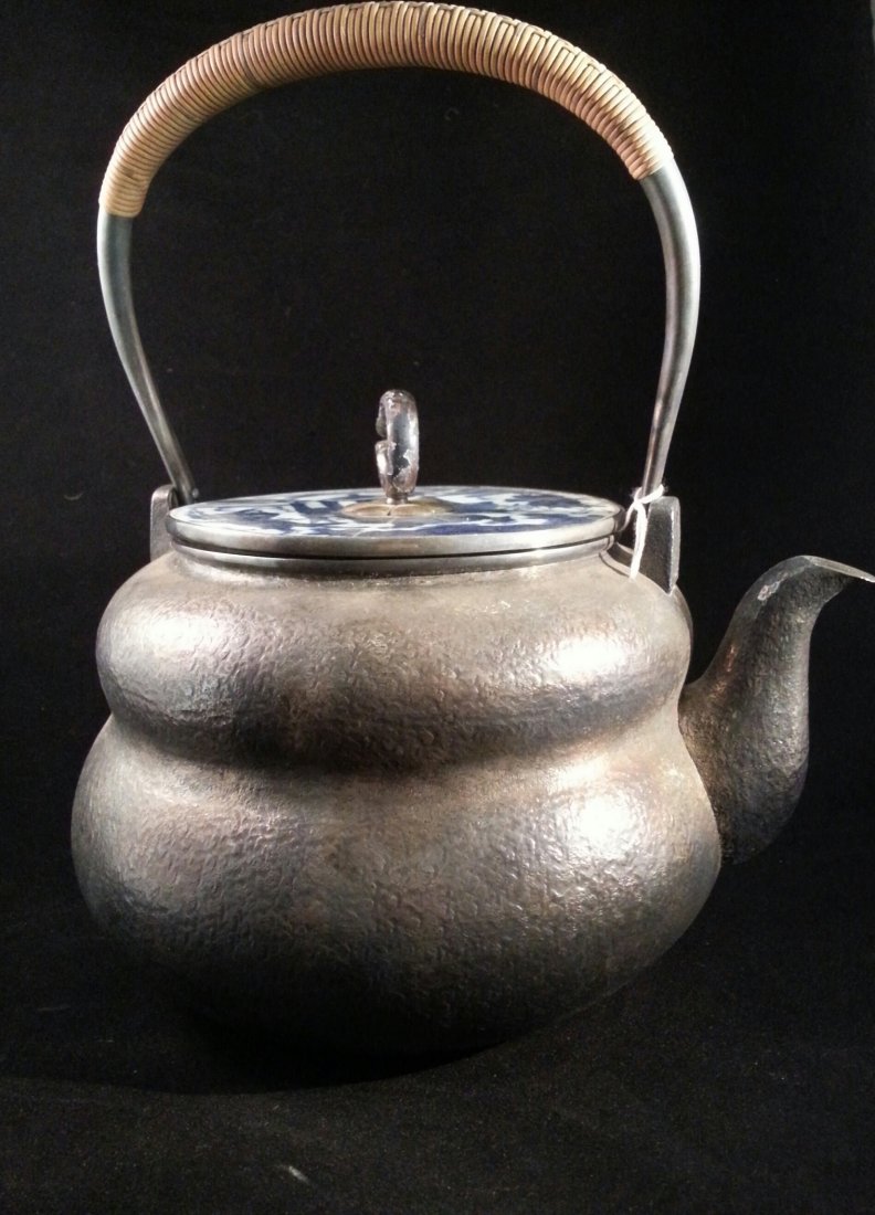 Japanese sterling silver teapot: 19th century Japanese sterling silver teapot, handle covered in woven bamboo.Lid made of Ming dynasty blue and white porcelain jar lid, with design of immortals and lion dog with litter atop it's back
