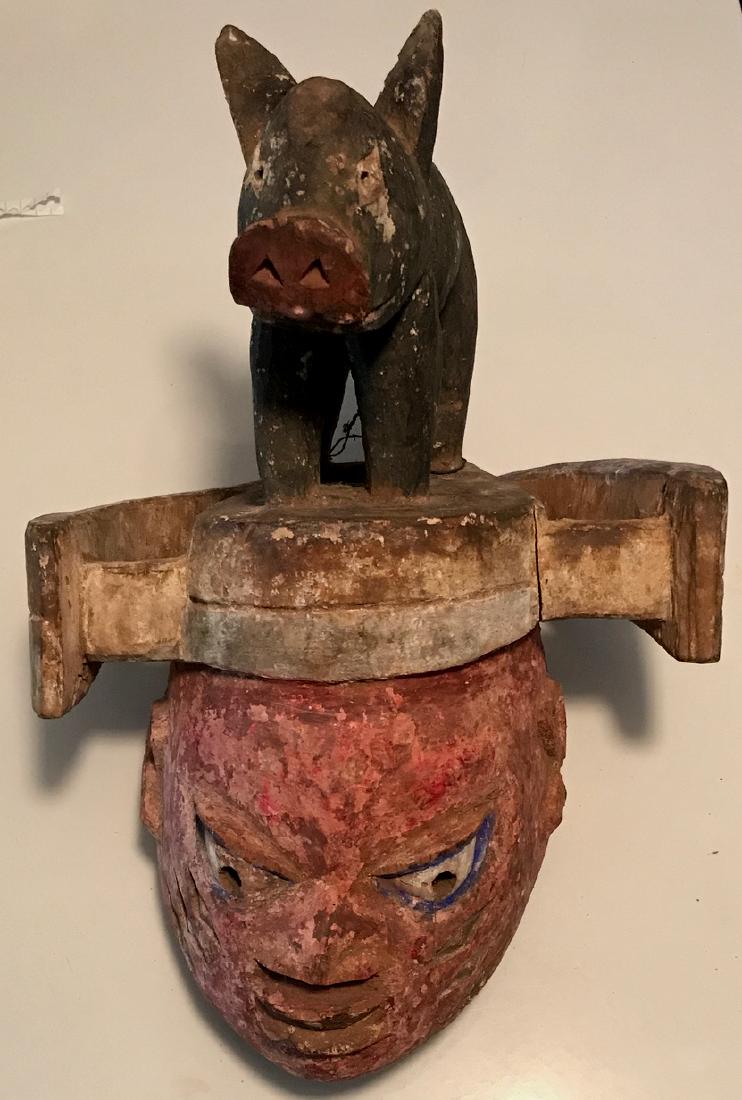 African Carved Ritual Bush Pig Helmet Mask: Nigeria,Yoruba Gelede carved folk art ceremonial mask. Carved and polychrome painted helmet-shaped, with a full body bush pig headdress. Dimensions: 17" hgt. x 11" wd. x 7" dp. Condition: good origina