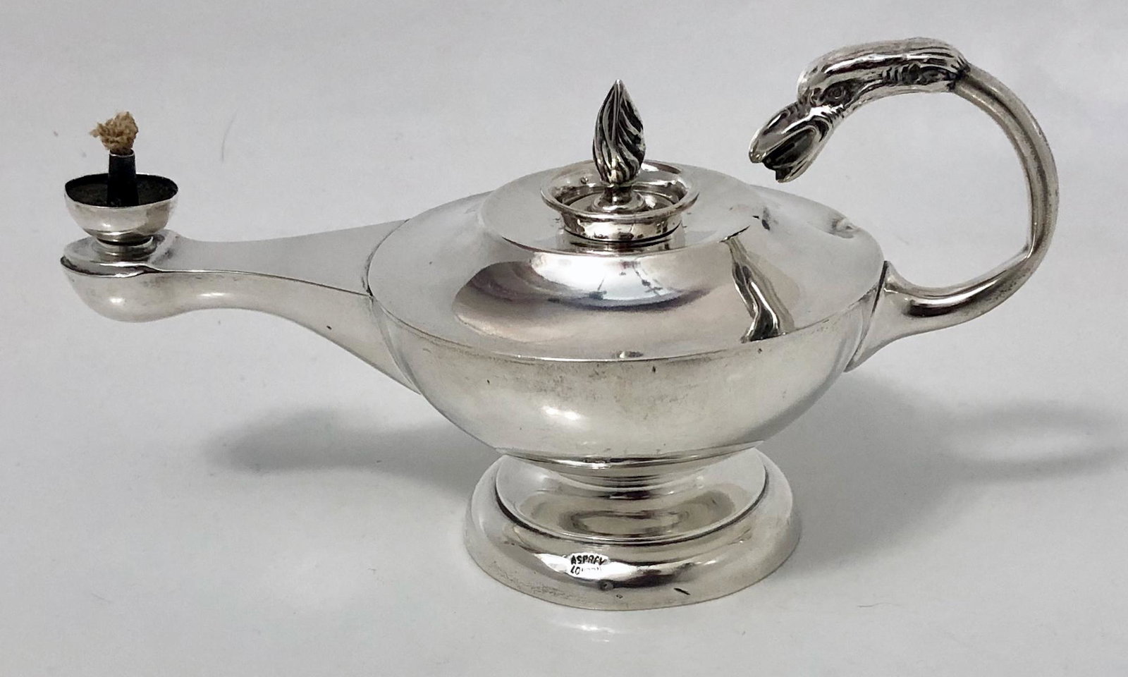 Antique Sterling ALADDINS Oil Lamp, Asprey of London: British sterling silver griffin handle oil lamp. Fully hallmarked-Asprey London. Weight approx: 94 grams. Dimensions: H: 3 1/2 in., W: 5 in. Condition: good original overall condition, small dings not