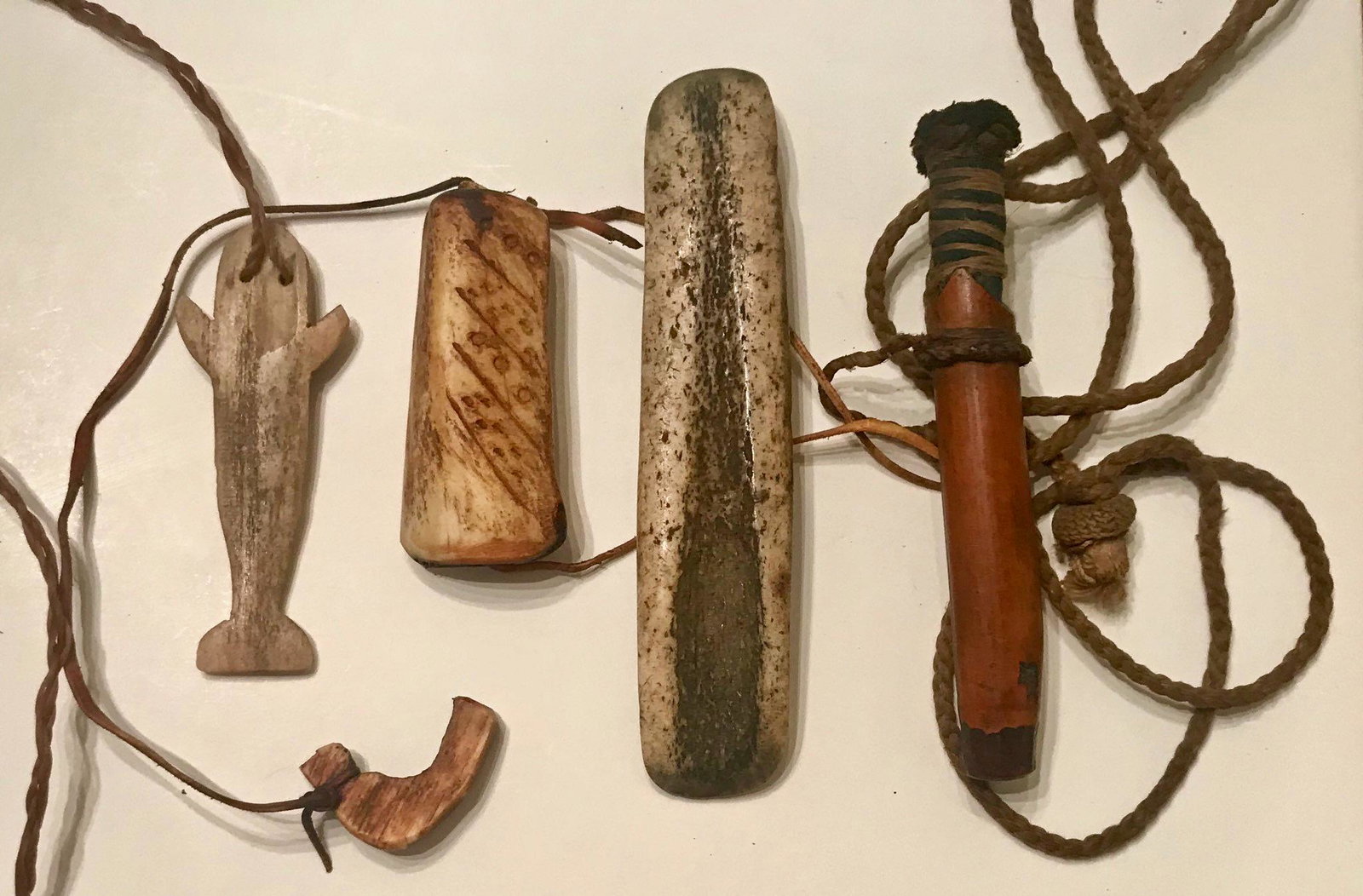 Eskimo Inuit Fishing Artifacts, Alaska: Alaskan native fishing artifacts. Whale bone figural carving, bow guard, needle case and a fossilized tool. Condition: good original estate condition, well-preserved. Provenance: private estate.