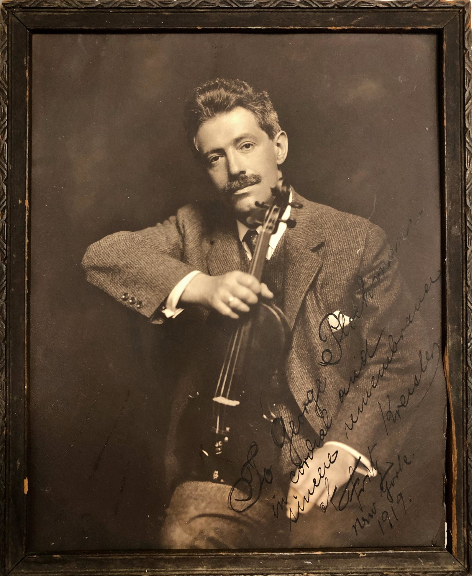 Fritz Kreisler Autographed Inscribed Photograph, 1919: Violinist Fritz Kreisler (Austro-Hungarian, 1875-1962). Portrait photograph of Kreisler seated holding his violin. Inscribed and signed in ink to: GEORGE PLOCHMANN In Cordial and Sincere Remembrance F