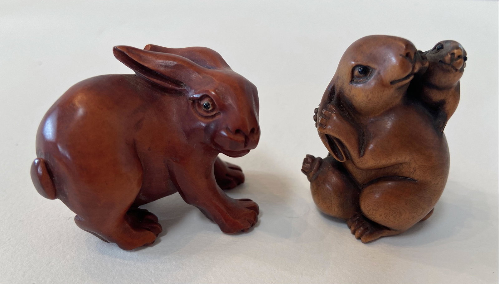 Two Japanese Carved Wood Netsuke, Form of Rabbits: Two Carved Japanese Netsuke in the Form of Rabbits. Rabbit with baby bunny atop, signed by the artist. Dimension: height: 1 3/4 in. Standing rabbit. Dimension: height: 1 1/2 in. Condition: good origin