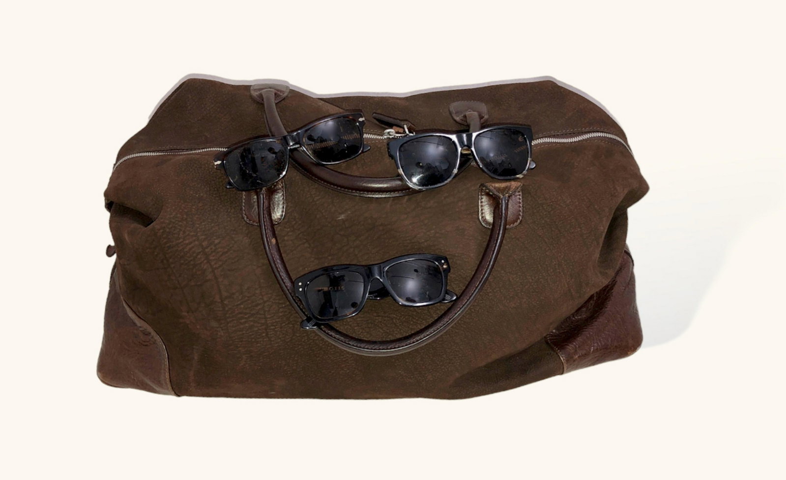 Mens Classic Collection of Designer Luggage & Eyewear: BRING THE WHITE LOTUS OUT IN YOU. PACK YOUR FUN. MOORE AND GILES Benedict Weekend Bag In American Bison. Condition: like new, unused luggage tag & shoulder strap. UNPACK YOUR DESIGNER SUNGLASSES. OTIS