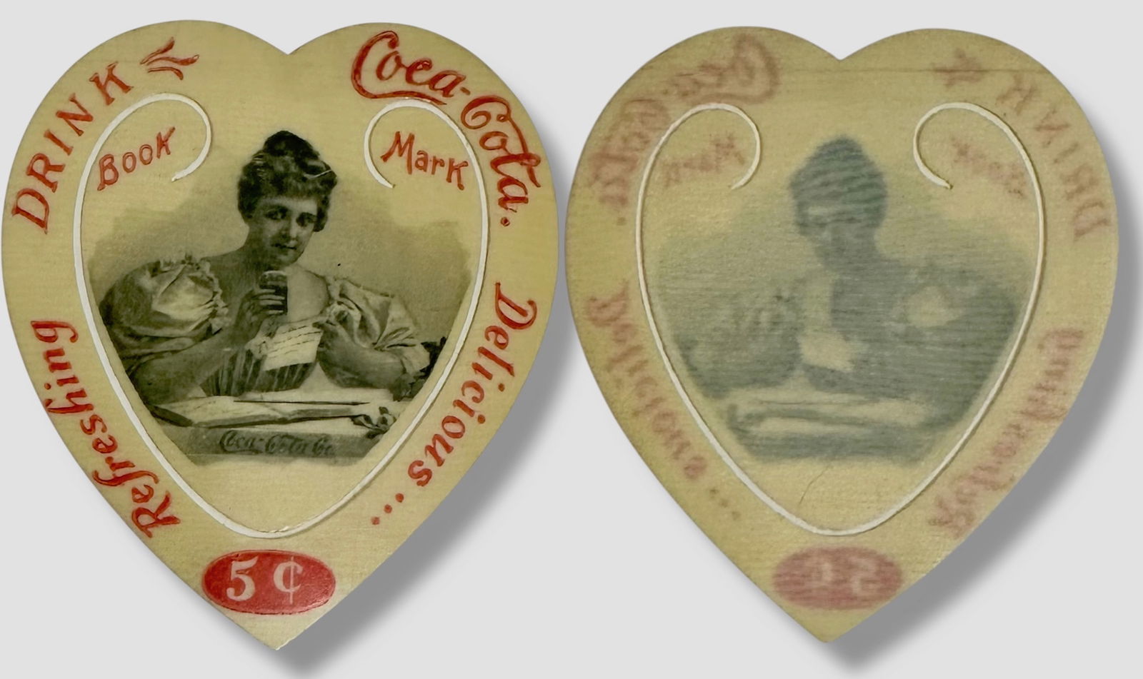 Antique 1898 Coca-Cola Celluloid Heart Shaped Advertising Bookmark: Rare Classic Coca-Cola Collectible. Vintage 1898 Celluloid Coca-Cola Heart Shape Bookmark Advertisement. Image of a Victorian lady drinking a glass of Coca-Cola with their classic slogan: Drink Coca-C