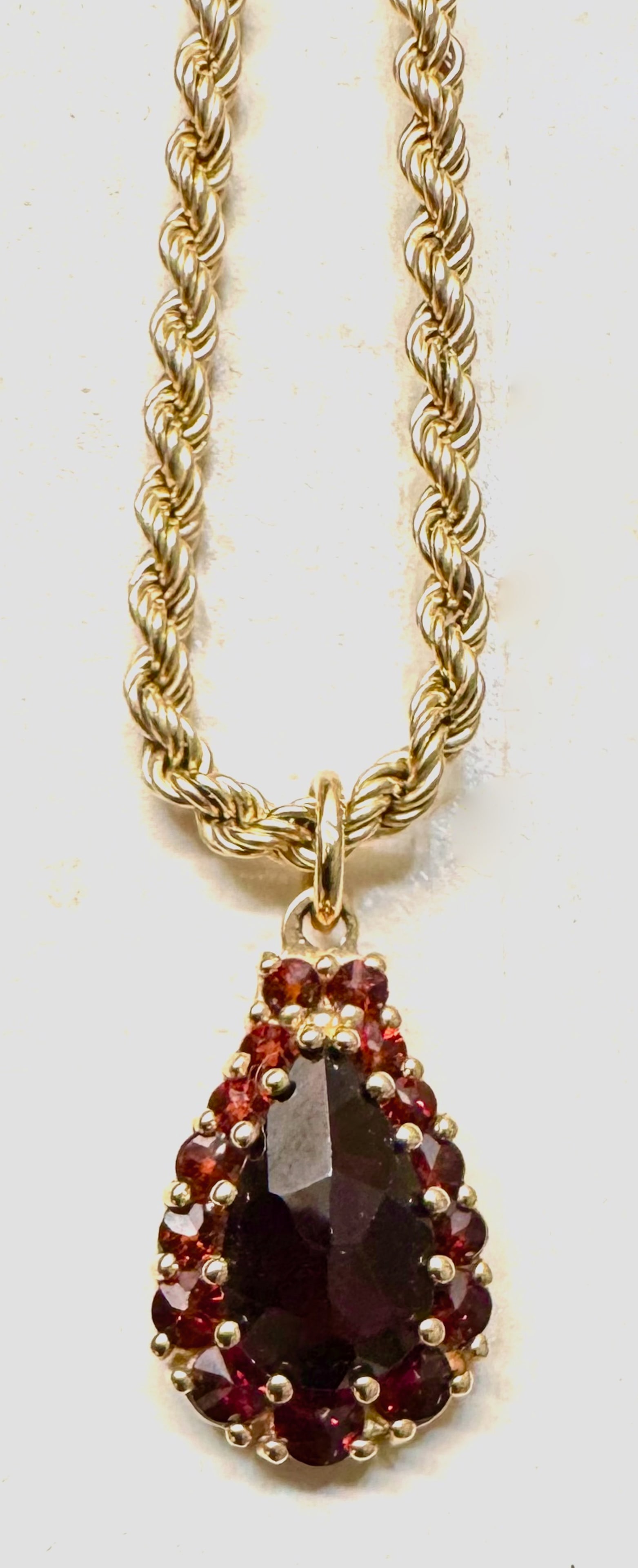 Estate 14k Yellow Gold Garnet Cluster Pendant Necklace: Estate 14k yellow gold garnet cluster Pendant necklace. Full-cut center garnet gemstone, encircled by a border of 16 matched round-cut accent garnets. The pendant comes complete with a solid 14k yello