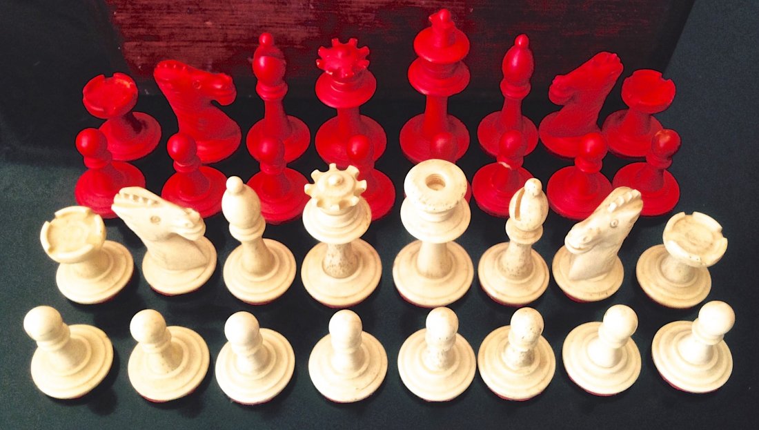 Hand Carved Bone Chess Set, Complete: Antique Hand Carved Bone Chess Set. Complete. Natural and red dye carved chess pieces within wood box Dimension: Piece Range 1"-1.7" Good condition, one top cross piece of king missing Provenance: Pri