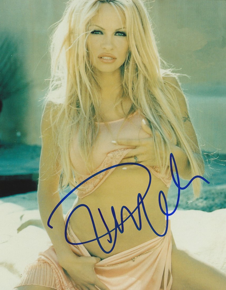 Pamela Anderson- Signed Photograph: 8X10 Color Glossy sexy photograph signed in person by Pamela Anderson in blue felt tip ink on October 13, 2000 at the Newsroom Restaurant on Robertson Blvd in LA, CA. Comes with a COA from IPA Network