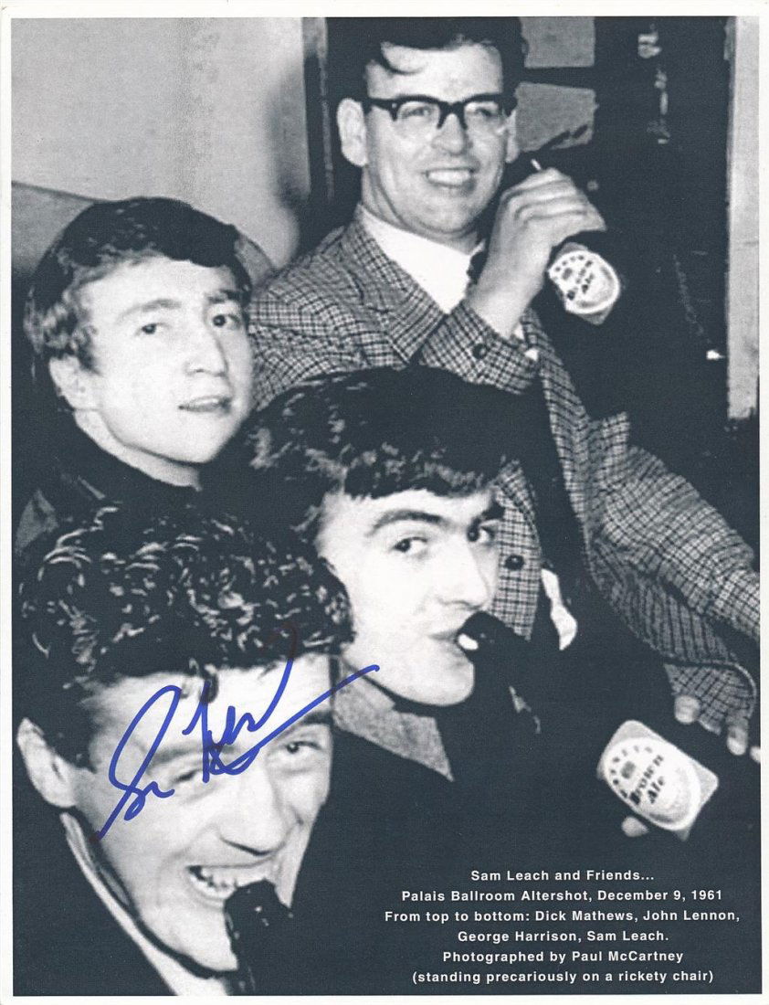 Sam Leach- (Early promoter of the Beatles)Signed Photo: 8.5X11 B&W cardstock photograph of Dick Mathews, John Lennon, George Harrison and Sam Leach at the Palais Ballroom drinking Ale together. Signed in blue felt tip ink nicely by Sam Leach. In very good