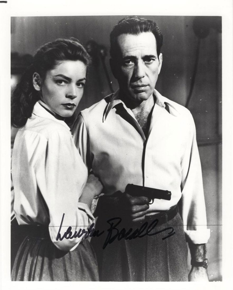 Lauren Bacall- Signed Photograph with Bogart: 8x10 B&W glossy finish photograph from, "Key Largo", signed in black felt tip ink by Lauren Bacall. The photograph also features Humphrey Bogart. In very good condition. (1924-2014) Lauren Bacall was
