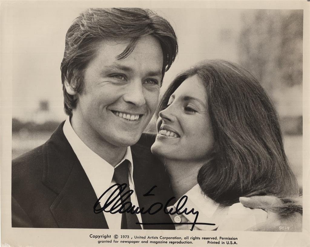 Alain Delon- Signed Vintage Photograph from "Scorpio": 10x8 Sepia glossy finish vintage photograph from the 1973 film "Scorpio" staring Alain Delon and Gayle Hunnicutt. Signed in black felt tip ink by Alain Delon. Some edge creasing, otherwise, in very go