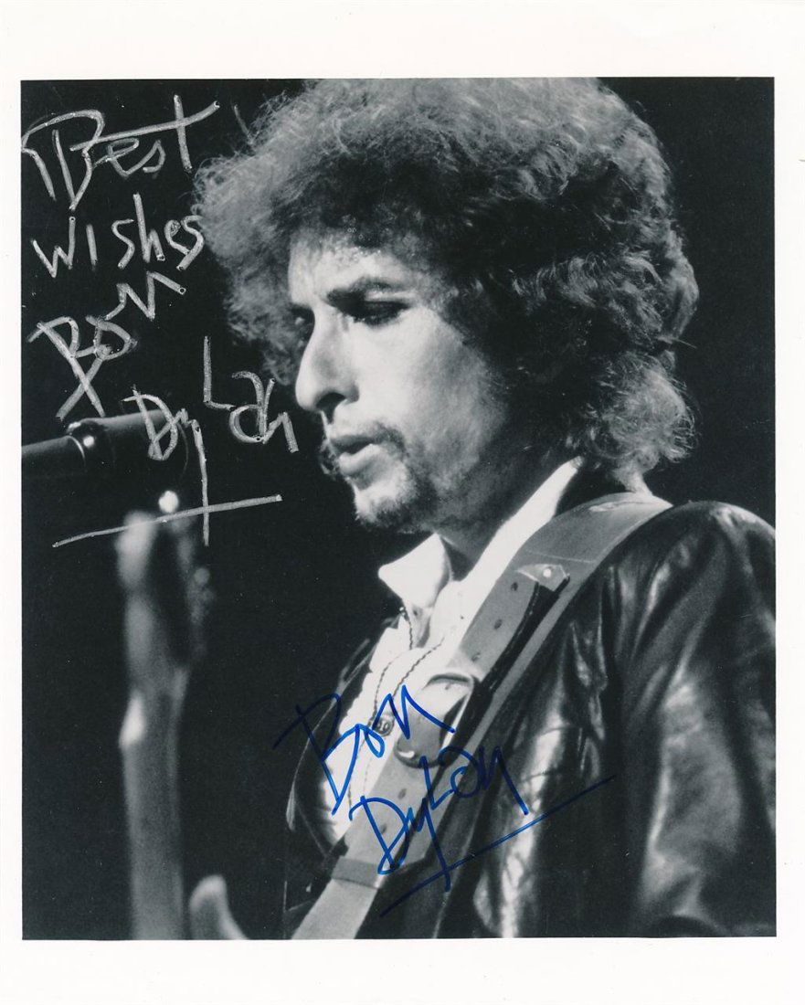 Bob Dylan- RARE Terrific Signed Photograph: 8X10 B&W Glossy photograph containing a pre printed signature in the upper left corner. Signed in blue felt tip ink by Bob Dylan below. In excellent condition.This lot came from the Jim Wiggins collec