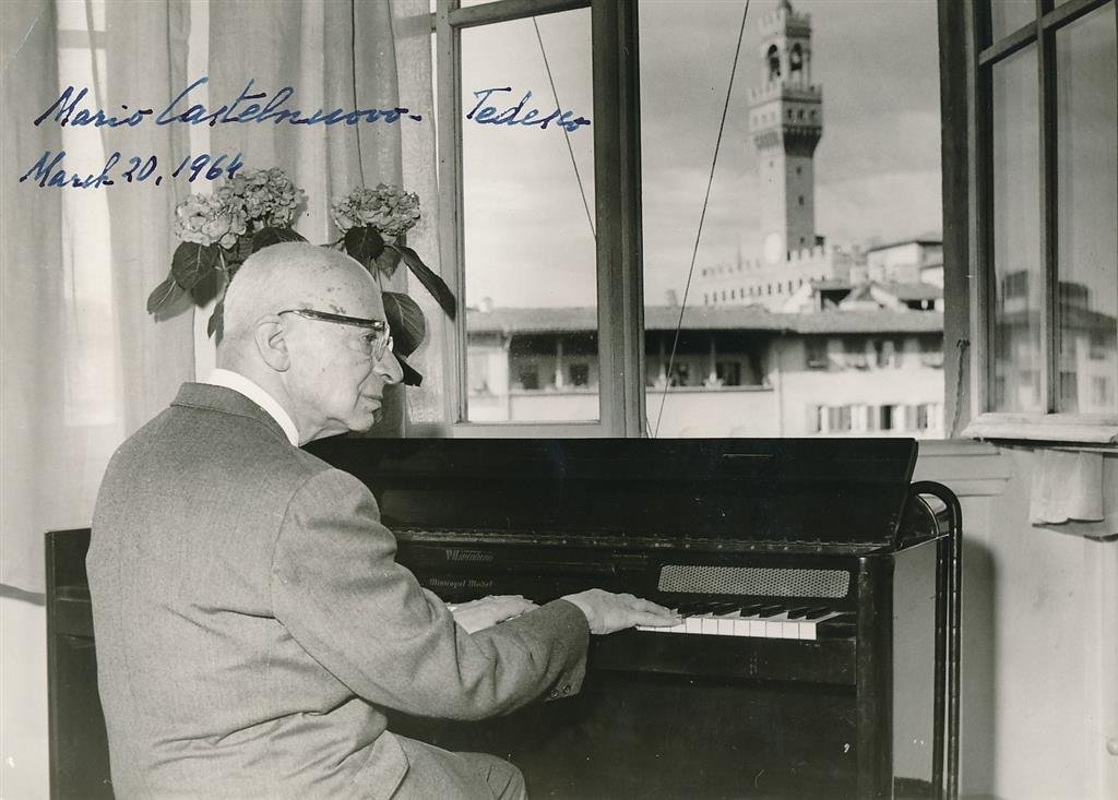 Mario Castelnuovo-Tedesco-Vintage Signed Photo (Italian Composer): 9.5X7 B&W Glossy vintage photograph of Mario Castelnuovo-Tedesco playing the piano. Signed in blue fountain pen ink in full, "Mario Castelnuovo-Tedesco March 20, 1964." Upper left corner crease, other