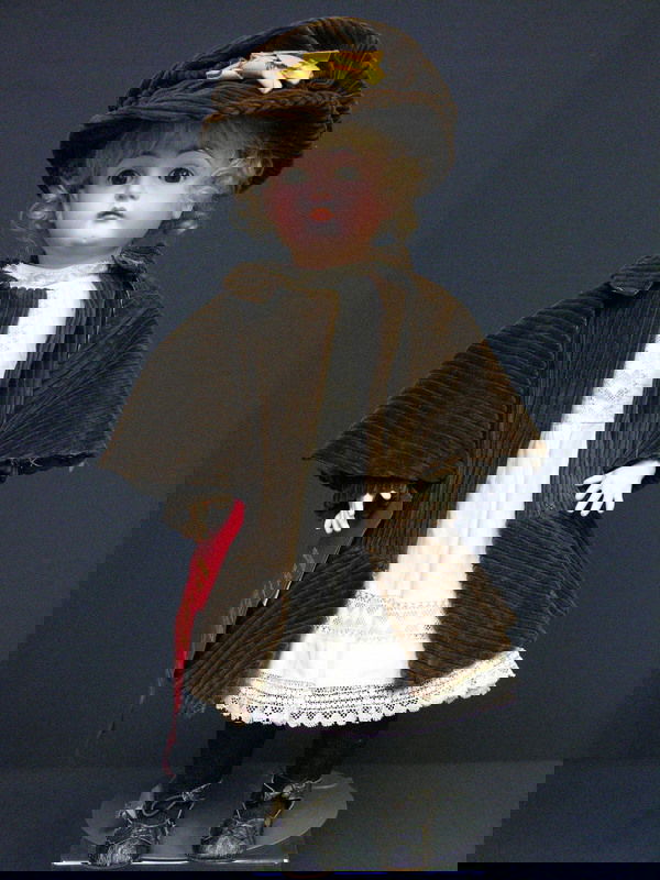 18IN KESTNER VERY POUTY CLOSED MOUTH: 18IN KESTNER VERY POUTY CLOSED MOUTH Bisque socket head, ball jointed body, brown sleep eyes, square face, year 1880, blonde hair, Costume: original white dress, brown corduroy coat and hat with yello