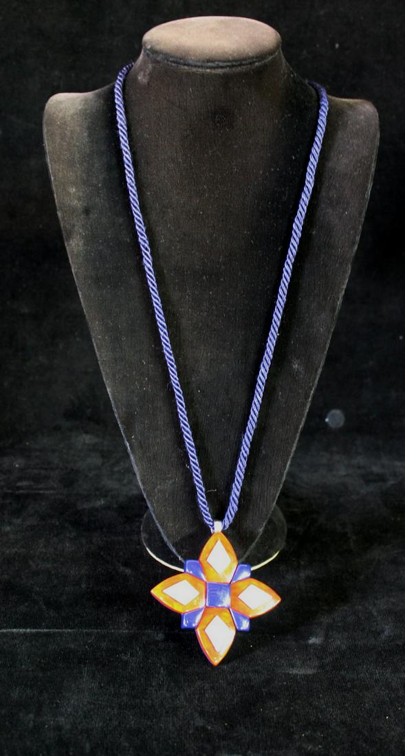 YVES SAINT LAURENT RIVE GAUCHE ENAMEL PENDANT ON CORD, CORD 36" TO TASSELS, PENDANT 3.5"L: YVES SAINT LAURENT RIVE GAUCHE ENAMEL PENDANT ON CORD, CORD 36" TO TASSELS, PENDANT 3.5"L