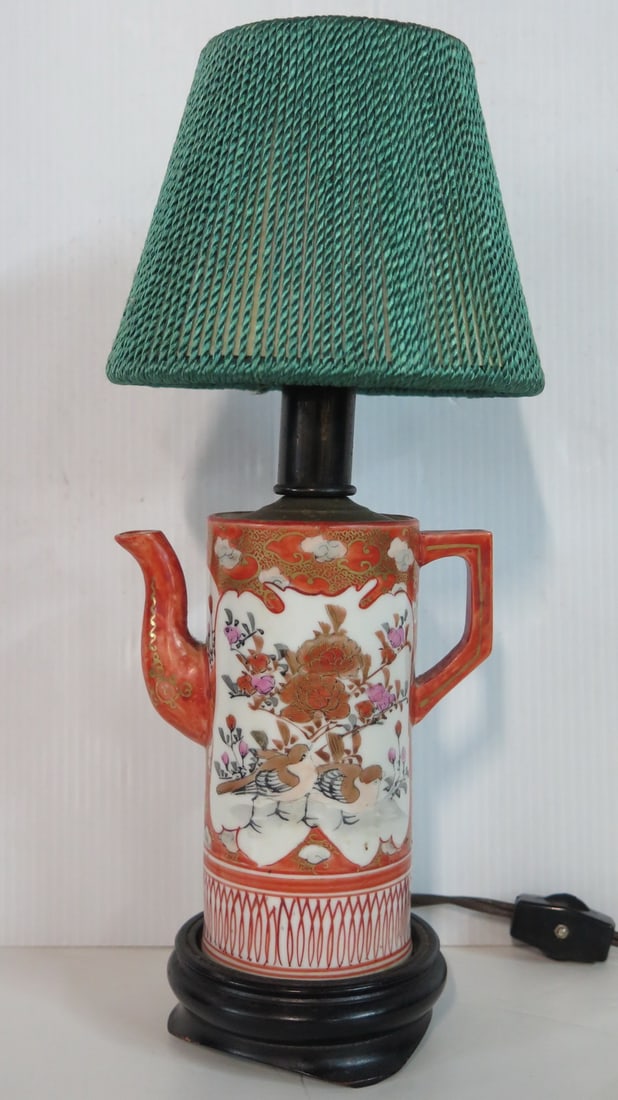 LIVING ESTATE OF JOSEPH RODANO: CHINESE PORCELAIN LAMP: This Chinese porcelain lamp is 11.5 inches tall, including the shade. The ceramic base has a smooth finish and a classic design. The shade is made of green fabric and has a floral pattern. This lamp w