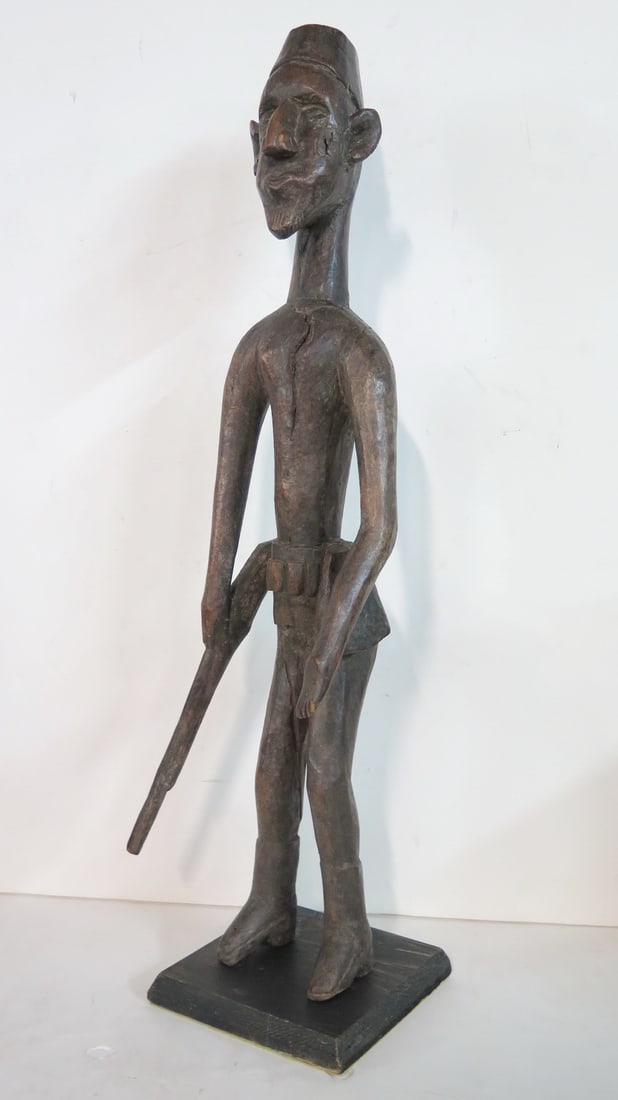 LIVING ESTATE OF JOSEPH RODANO: TRIBAL WOODEN FIGURE OF A MAN 26.5'H: This striking tribal wooden figure captures the essence of traditional African art, standing at an impressive 26.5 inches tall. The sculpture depicts an elongated male form with exaggerated features c