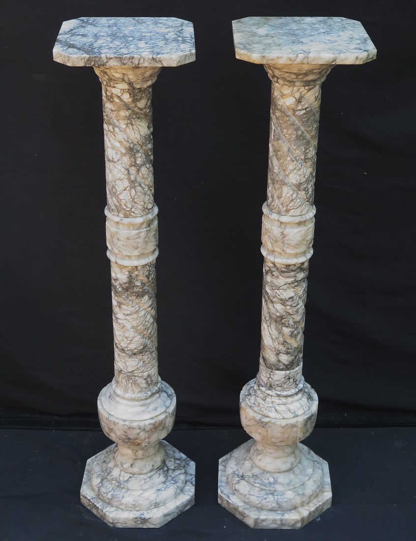 ESTATE OF DENNIS P. RODANO: PAIR OF MARBLE PEDESTALS, 39"H: Elevate your home décor and art displays with this elegant pair of marble pedestals. Standing 39 inches tall, these stately pedestals are crafted from high-quality marble and boast a polished finish