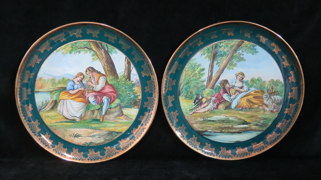 ESTATE OF DENNIS P. RODANO: PAIR OF ITALIAN PORCELAIN CHARGERS WITH GREEN AND GOLD BORDER 14"DIA.: Elevate your dining experience with a touch of Italian flair using this captivating pair of 14-inch diameter porcelain chargers with a green and gold border. These decorative plates would make a stunn