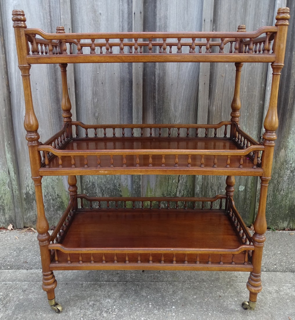 THREE TIERED FRUITWOOD DESSERT TROLLEY: A three-tiered fruitwood dessert trolley, measuring 37.25 inches in height, 28.5 inches in width, and 17 inches in depth, offers a versatile and elegant piece of furniture. The rich fruitwood finish c