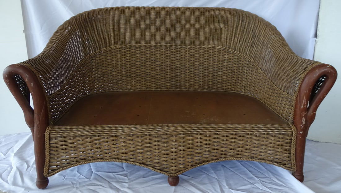 VINTAGE WICKER SETTEE WITH SWAN FIGURAL ARMS: This unique, vintage wicker settee features a charming and whimsical design, with intricately woven wicker forming the frame and swan-shaped figures adorning the arms. The settee's curved shape and co