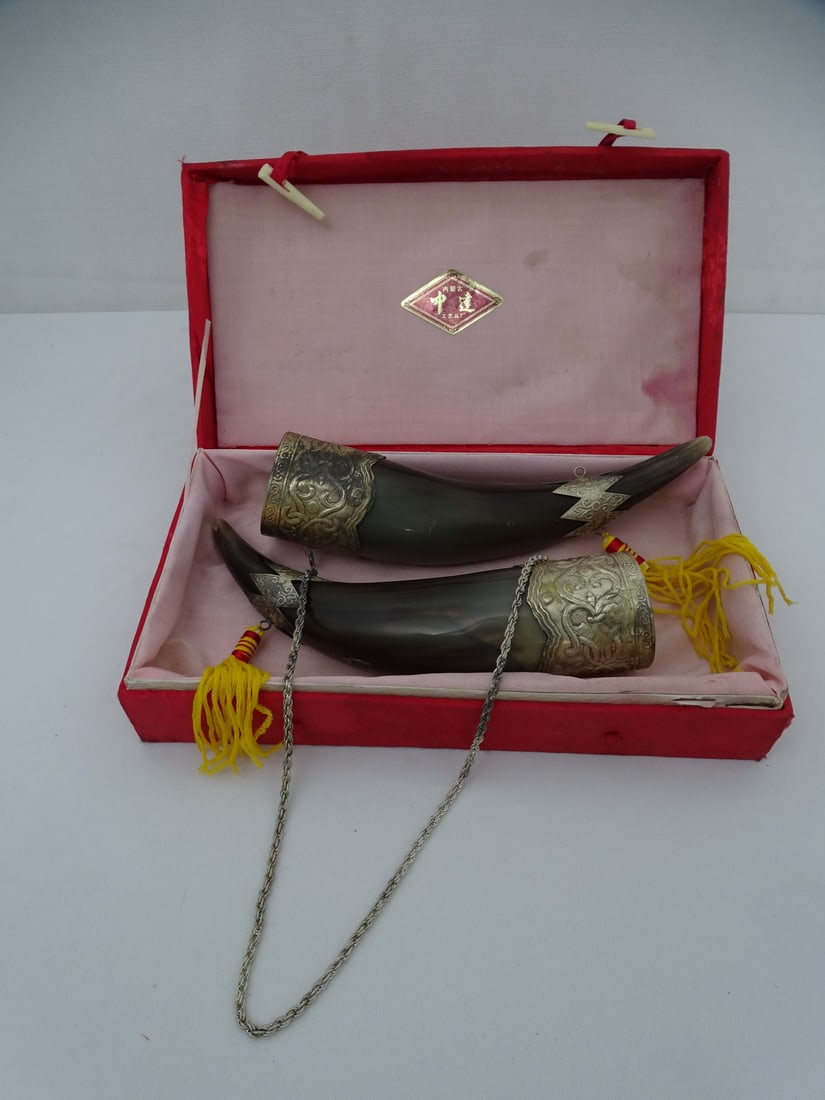 ZHONGDA INNER MONGOLIAN DRINKING HORN SET WITH METAL ADORNMENTS: This unique Zhongda Inner Mongolian drinking horn, adorned with intricate metalwork, is a fascinating piece of cultural heritage. The horn, likely made from the horn of an animal such as a yak or ox, 