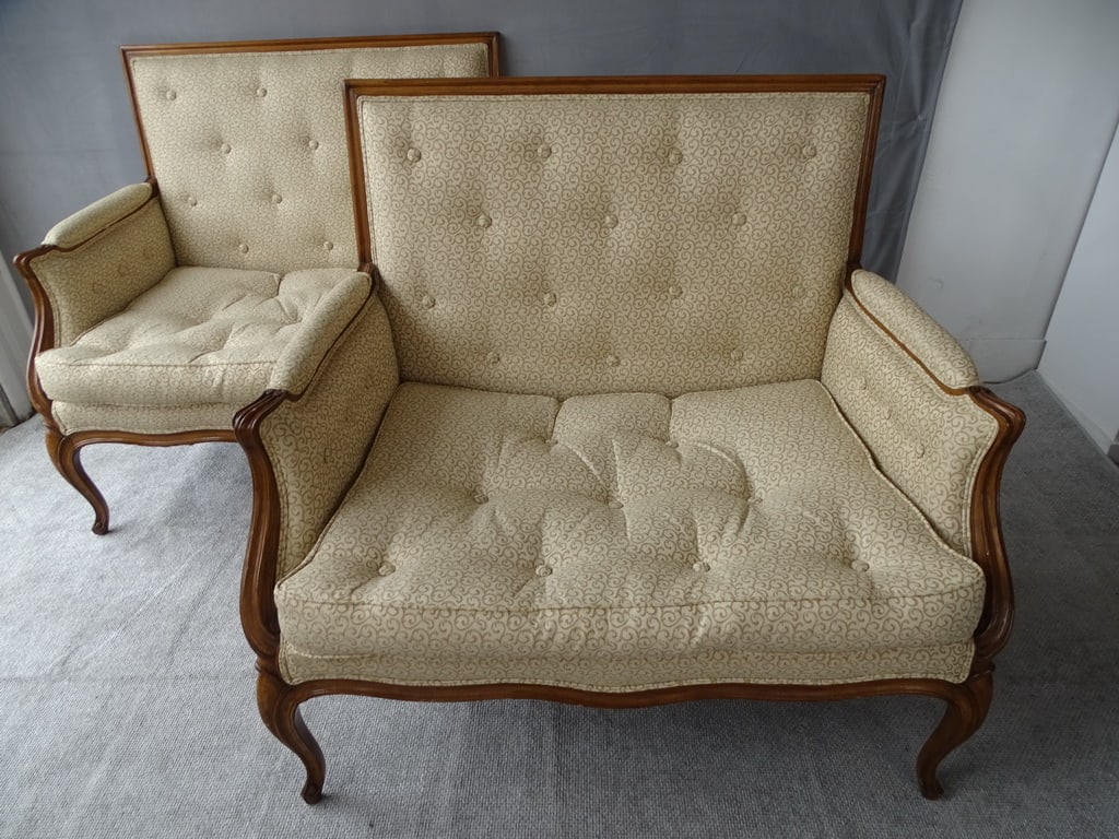TWO BERGERE CHAIRS: This pair of Louis XV-style bergère chairs is a testament to fine craftsmanship and elegant design. The walnut frames, adorned with intricate carvings and graceful curves, showcase the skill and arti
