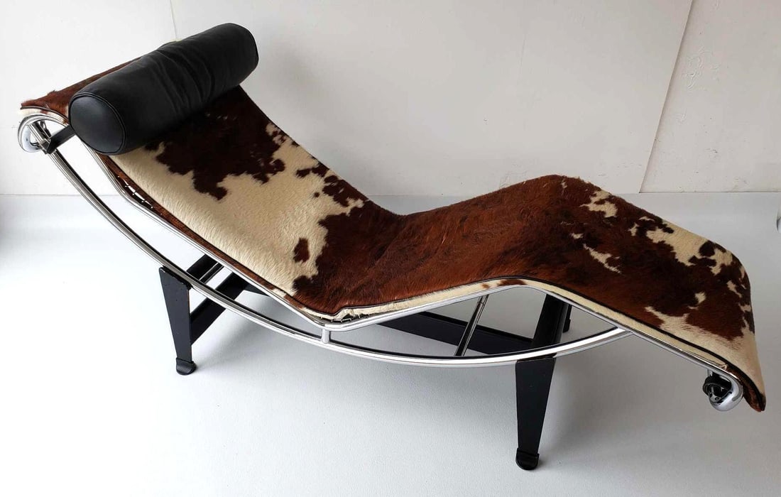 LE CORBUSIER COWHIDE AND TUBULAR STEEL CHAISE LOUNGE: This iconic vintage chaise lounge, designed by the renowned architect Le Corbusier, is a masterpiece of modern furniture design. This particular example produced by Cassina features a striking combina