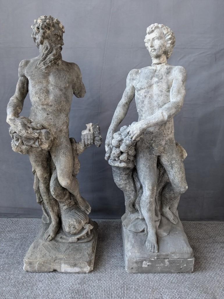 TWO VINTAGE NUDE MALE CONCRETE FIGURES STATUARY: This captivating pair of vintage concrete figures exudes timeless charm and artistic appeal. Depicting two figures in dynamic poses, these sculptures likely represent a pair from a larger set of class