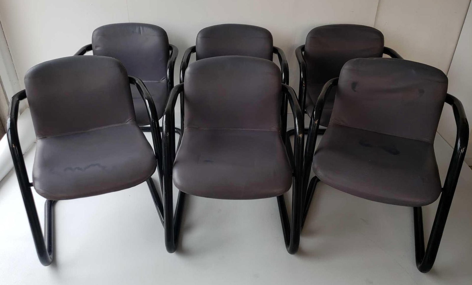 SET OF SIX KINETICS MID-CENTURY TUBULAR STEEL AND VINYL DINING CHAIRS: This set of six Kinetics mid-century tubular steel and vinyl dining chairs offers a stylish and practical seating solution with a distinct mid-century modern aesthetic. Each chair measures 29.75 inche