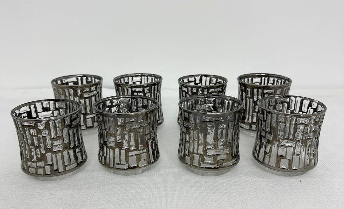 SET OF EIGHT BRUTALIST LIBBEY ARTICA PLATINUM ROCKS GLASSES: This set of eight rocks glasses exemplifies the bold and dramatic aesthetic of the Brutalist design movement. Crafted by Libbey, a renowned name in glassware, these glasses showcase a unique and strik
