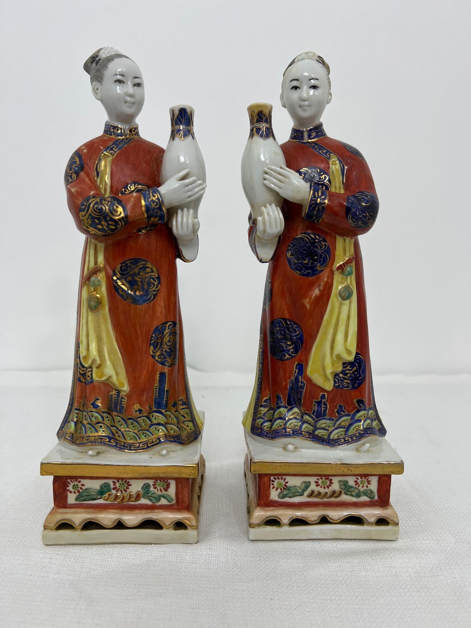PAIR OF CHINESE PORCELAIN FAMILE ROSE NODDING HEAD COURT LADY FIGURES: This captivating pair of Chinese porcelain Famille Rose nodding head court lady figures, standing at an impressive 12 inches tall, exemplifies the artistry and craftsmanship of this esteemed ceramic t