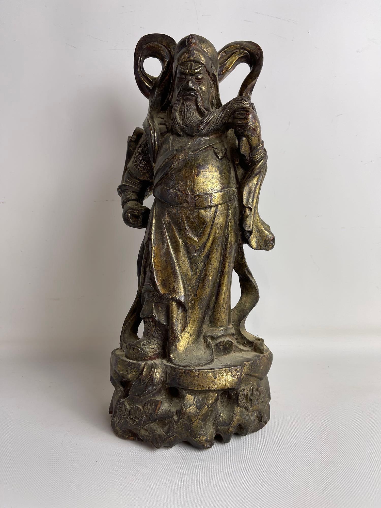 GILT WOOD STATUE OF CHINESE DEITY: This striking Chinese wooden figure possibly of Caishen, the god of money and wealth, stands 16" high, 7" wide, and 5" deep, making it a powerful representation of this revered Chinese myt