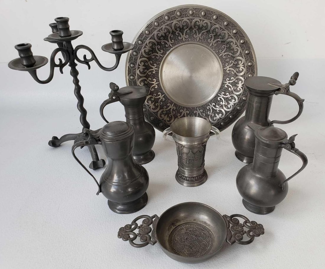 COLLECTION OF FINE PEWTER ITEMS INCLUDING SYRUP PITCHERS WITH ACORN FINIALS: This exquisite collection of fine pewter items showcases the beauty and craftsmanship of this versatile and enduring metal. The centerpiece of this assemblage is likely a striking candelabra, standing