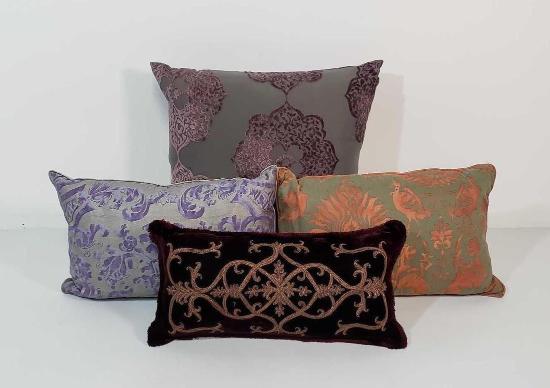 GROUP OF FOUR DESIGNER PILLOWS INCLUDING METALLIC SOUTACHE ON WINE VELVET: This curated group of four designer pillows, with the largest measuring 22" x 22", offers a luxurious assortment of textures and patterns to elevate your home décor. The collection features a variety