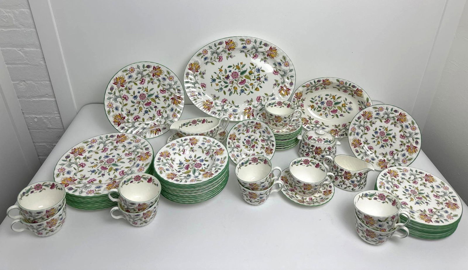 HADDON HALL MINTON BONE CHINA FLORAL SET: This exquisite Haddon Hall Minton bone china floral set is a testament to the timeless elegance of fine English porcelain, featuring the iconic Haddon Hall pattern with its delicate floral motifs and