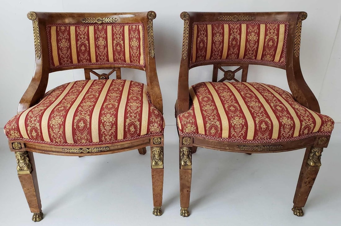 VALUE LOT: PAIR OF NEOCLASSICAL EGYPTIAN REVIVAL OLIVE BURLWOOD PARLOR CHAIRS: This elegant pair of Neoclassical Egyptian Revival parlor chairs showcases the sophistication and grandeur of the style. Crafted from rich olive burlwood, the chairs feature intricately carved details