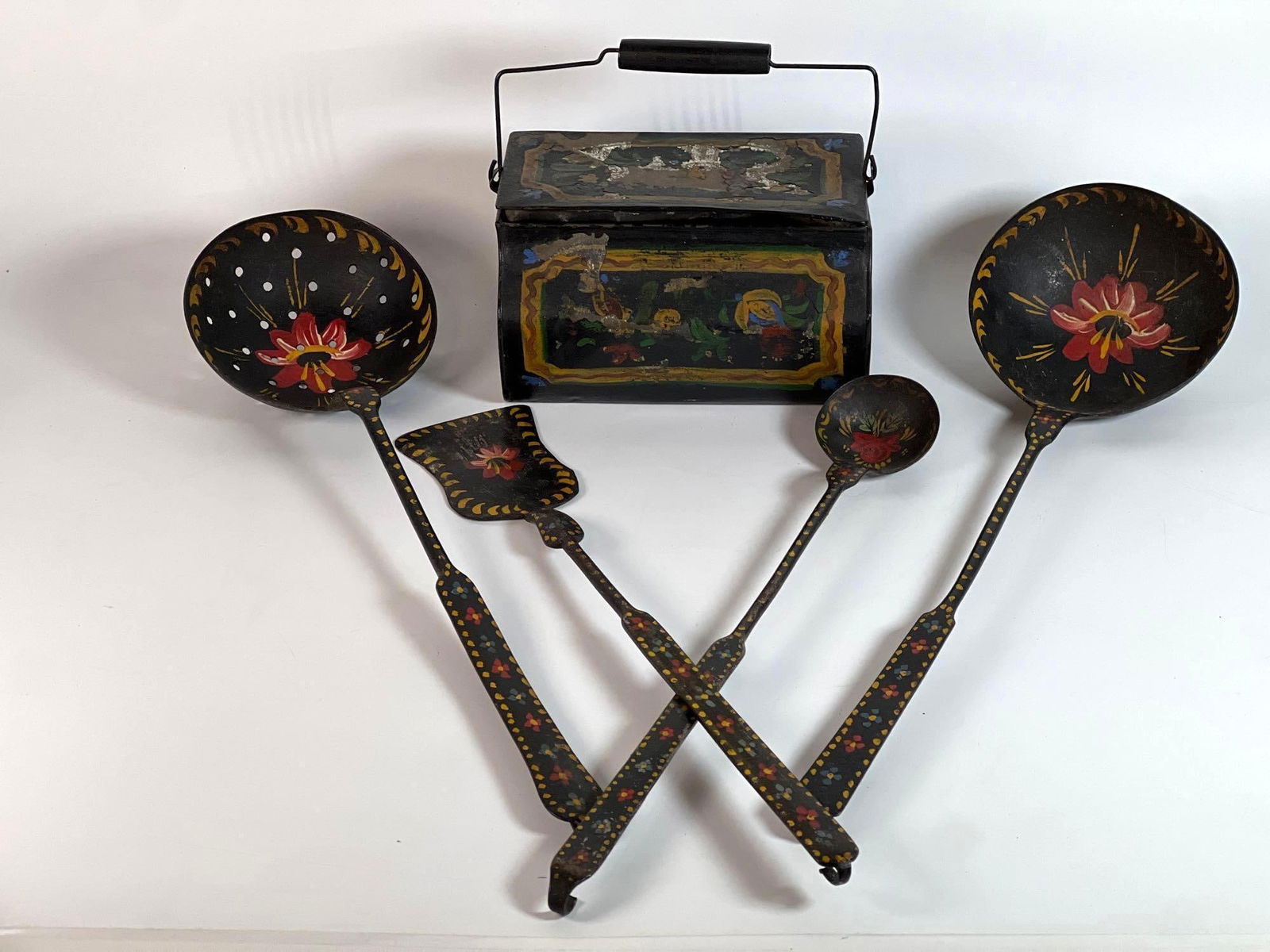 HAND-PAINTED CAST IRON COOKWARE SET AND DECORATIVE METAL BOX: This charming cast iron cookware set, accompanied by a decorative metal box (possibly tin), offers a glimpse into rustic kitchenware and folk art. The set includes various cast iron cooking utensils,