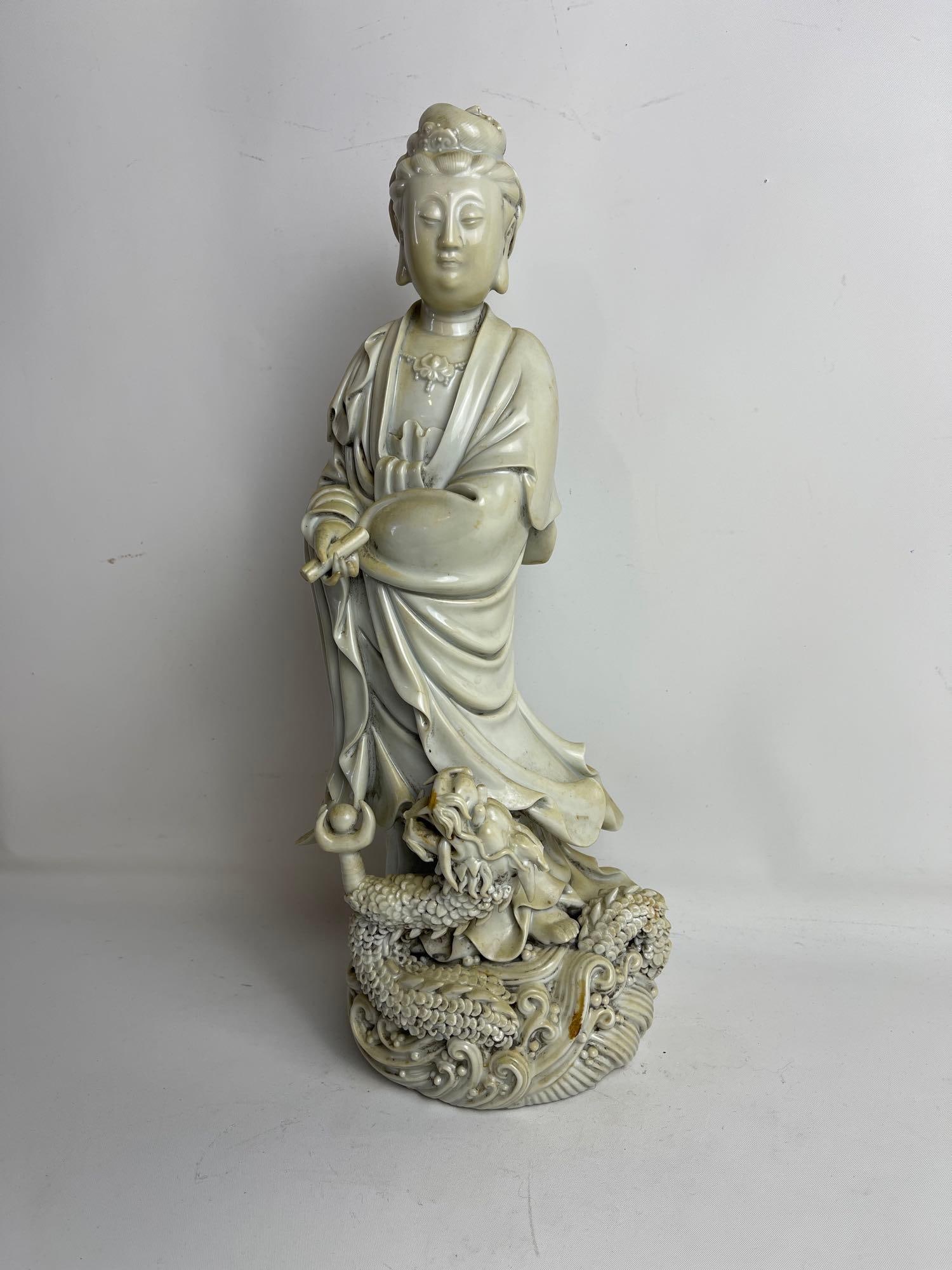 CHINESE BLANC DE CHINE STANDING GUANYIN FIGURE WITH SERPENT: Blanc de Chine standing Guanyin figure with sea serpent at feet. Impressed Chinese character mark to back. Created in the tradition of Chinese white porcelains made since the 10th century in Dehua a t