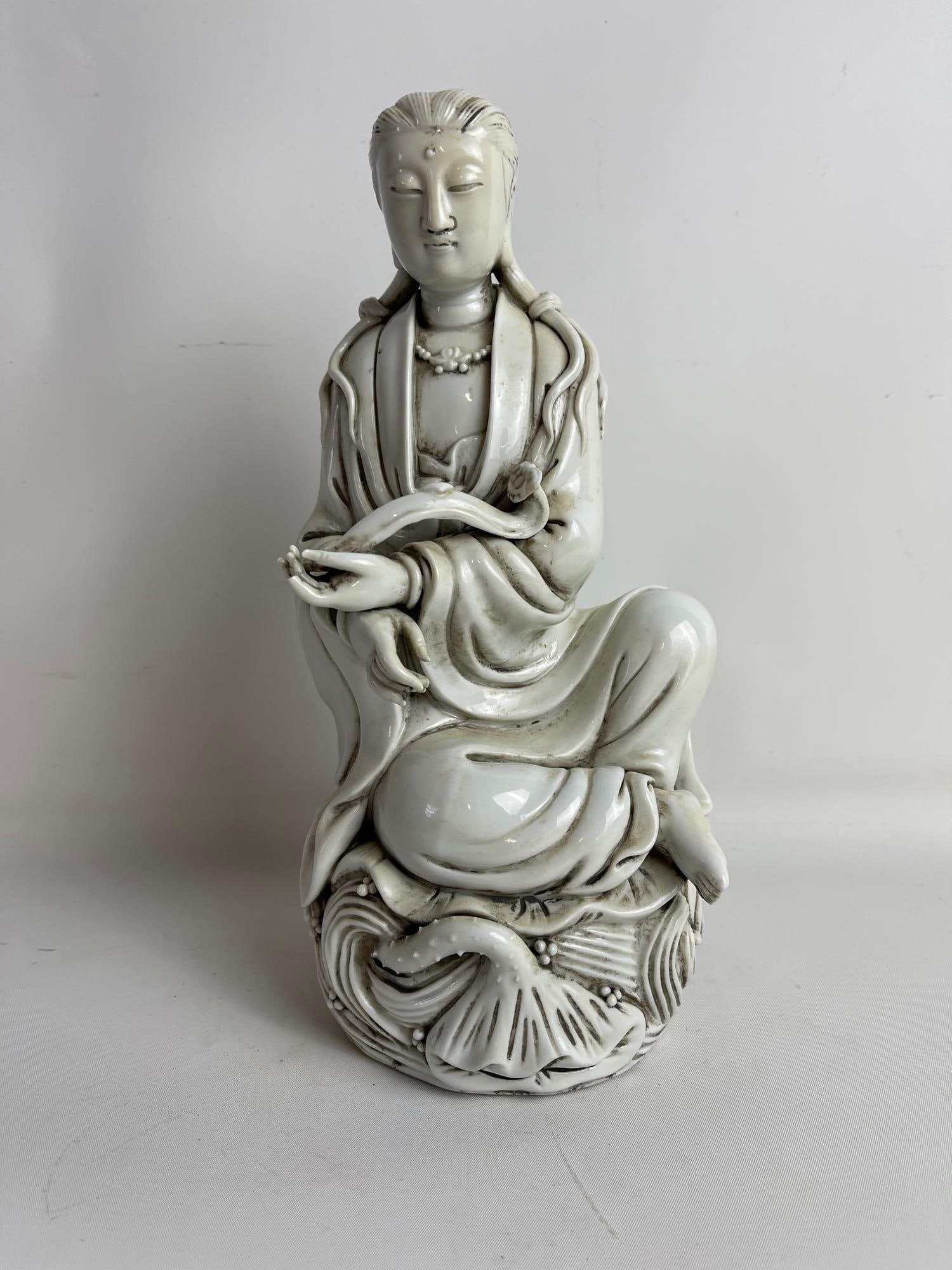 CHINESE BLANC DE CHINE DEHUA PORCELAIN SEATED GUANYIN FIGURE: This exquisite Chinese Blanc de Chine Dehua porcelain seated Guanyin figure, measuring 11.5" high, 5" wide, and 5" deep, exemplifies the serene beauty of Buddhist art and the refined craft