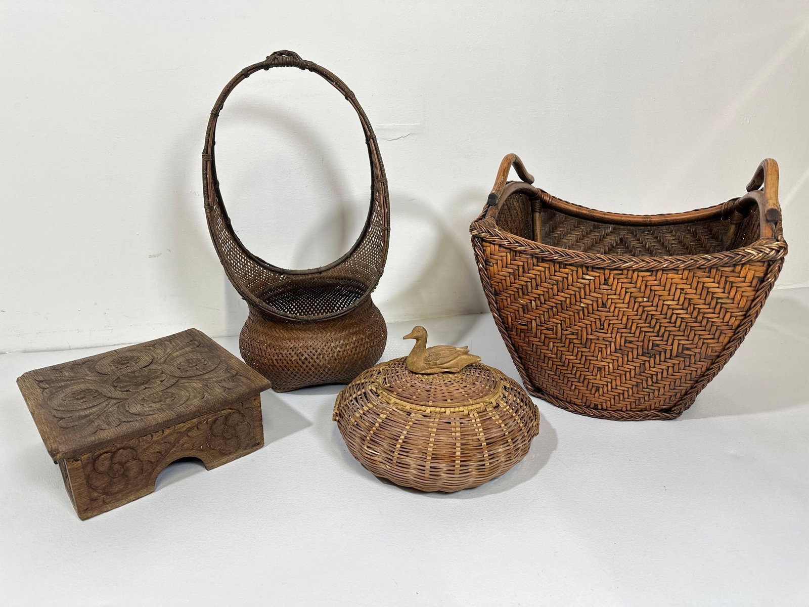 VALUE LOT: COLLECTION OF VINTAGE BASKETS AND CARVED STANDS: This curated collection of vintage baskets and carved stands offers a glimpse into the diverse traditions of basketry and wood carving. The assortment includes a variety of woven baskets, each showcas