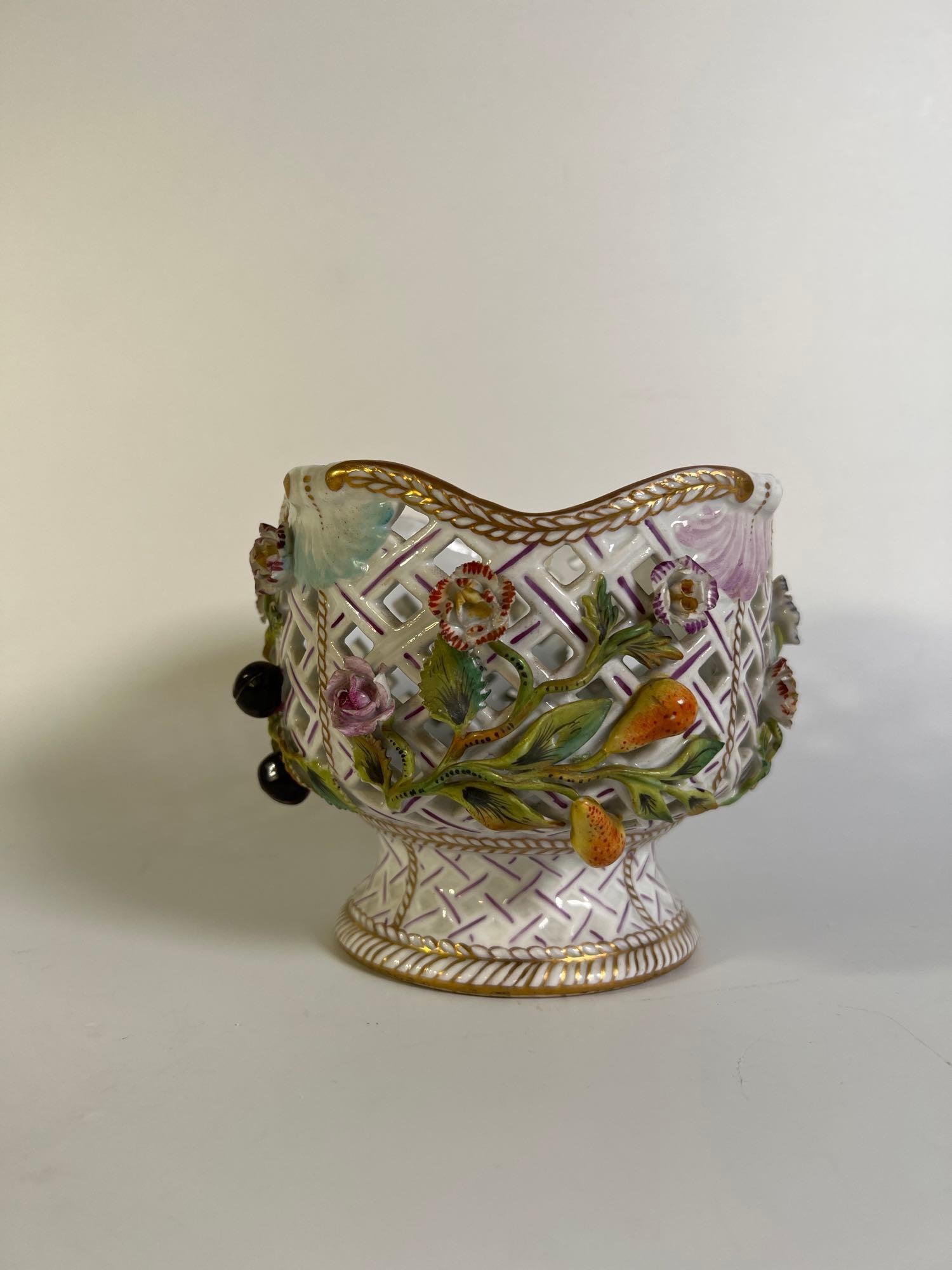 VALUE LOT: AUSTRIAN / GERMAN MEISSEN STYLE RETICULATED BOWL: An Austrian or German Meissen-style reticulated bowl, possibly Sitzendorf, featuring a pierced lattice design adorned with applied and hand-painted floral, fruit, and foliate decorations, finished wit