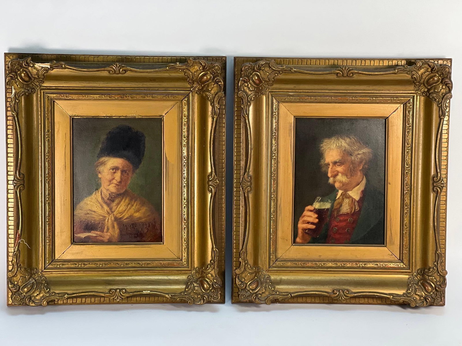 PAIR OF VINTAGE FRAMED OIL PAINTINGS: ELDERLY WOMAN IN BONNET & MAN WITH BEER MUG: A pair of vintage framed oil paintings, each in an ornate gold-toned frame, includes a portrait of an elderly woman wearing a dark bonnet and a patterned shawl, and a portrait of an older man with whi