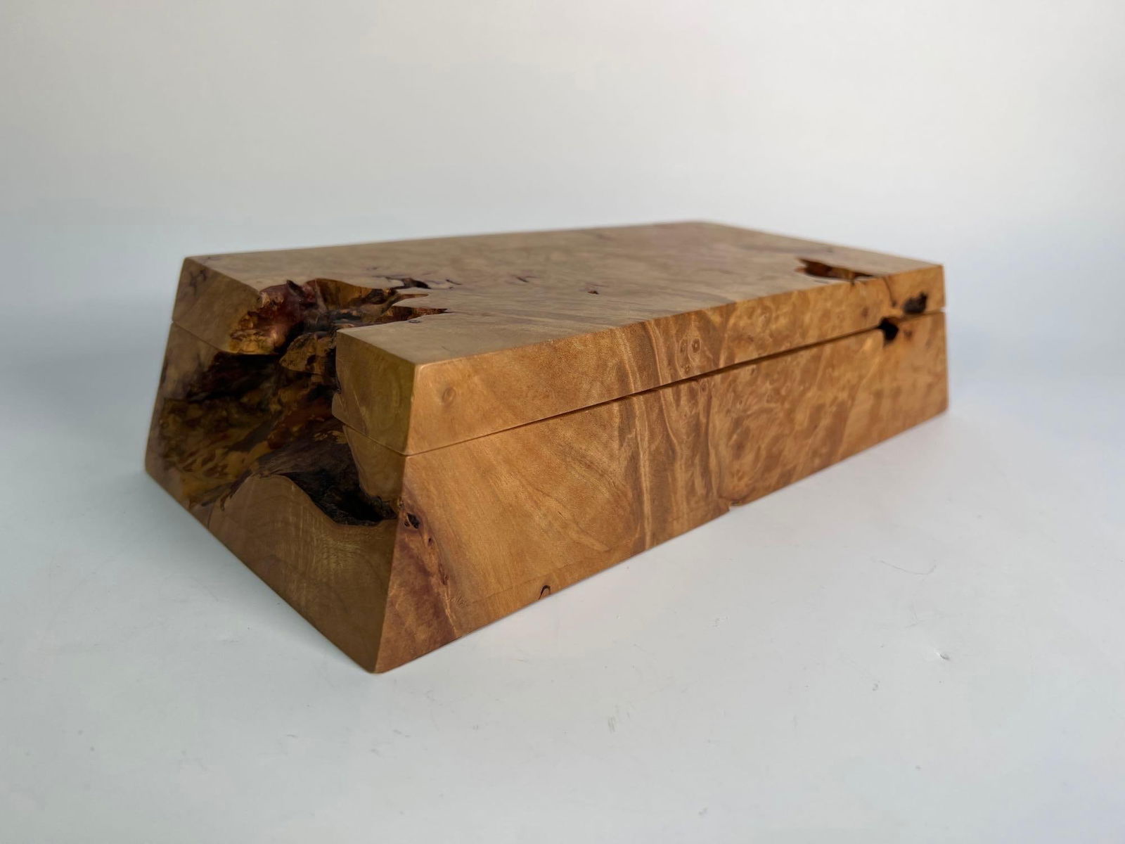 DAVID ELKAN CARVED BURLED BIRDSEYE MAPLE BOX: A rectangular box, handcrafted by Michael Elkan, is carved from highly figured burled birdseye maple wood, showcasing the wood's unique patterns and natural edges. Dimensions: 2.5” x 11.25&rdqu