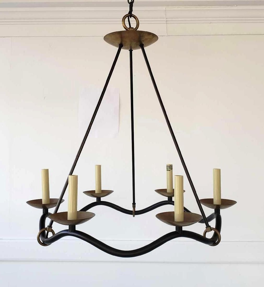 VISUAL COMFORT "CHOROS" CHANDELIER: A Visual Comfort "Choros" chandelier featuring a dark, curved frame supporting six candle-style lights with brass-toned cups and a matching canopy, suspended by a chain. Dimensions: 30"H x 28"D Arti