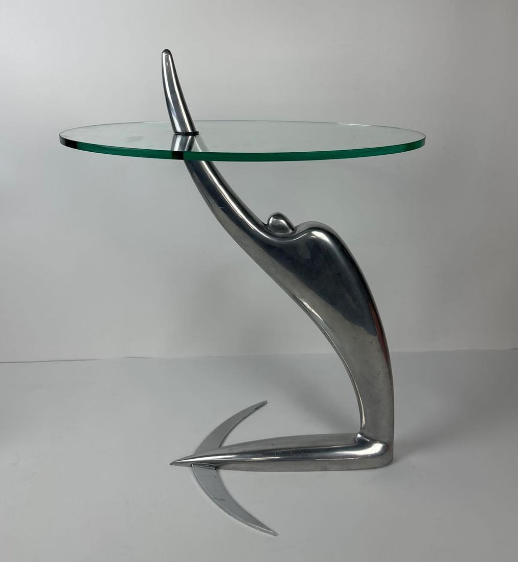 ARCADIA-SWING SIDE TABLE BY PIERANGEL CARAMIA FOR XO 1987: An art deco polished aluminum and glass side table with a table top designed to swing to any position. Dimensions: 25” Tall x 19” x 13 Notes: Although care is taken to photograph and descr